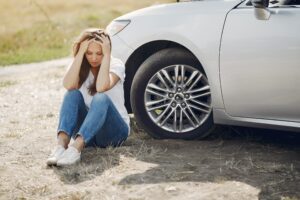 Voluntary repossession: a woman sits by her car in distress