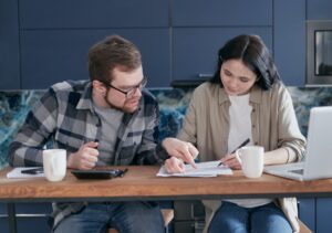 Man and woman sitting at the table trying to work out their debt consolidation efforts