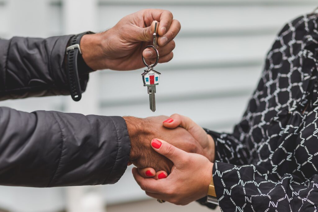 Person holding silver key after buying a house with their new mortgage